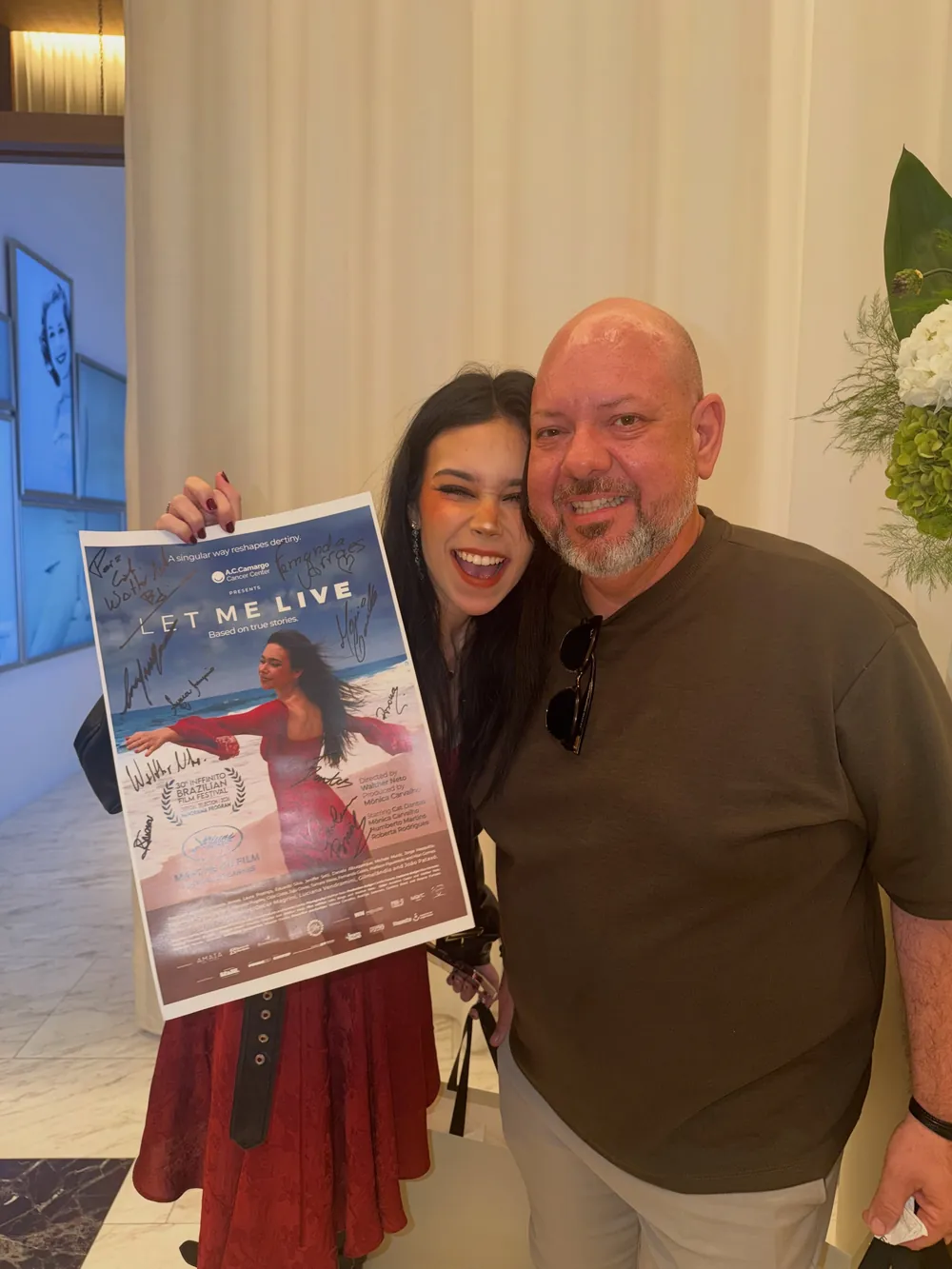 Cat Dantas holding the Let Me Live poster in Miami